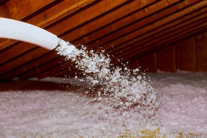 Fiberglass attic insulation being installed