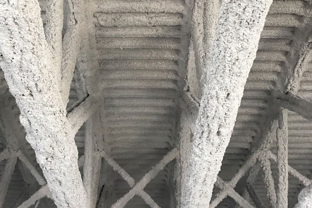 Worker applying fireproofing material to structural steel